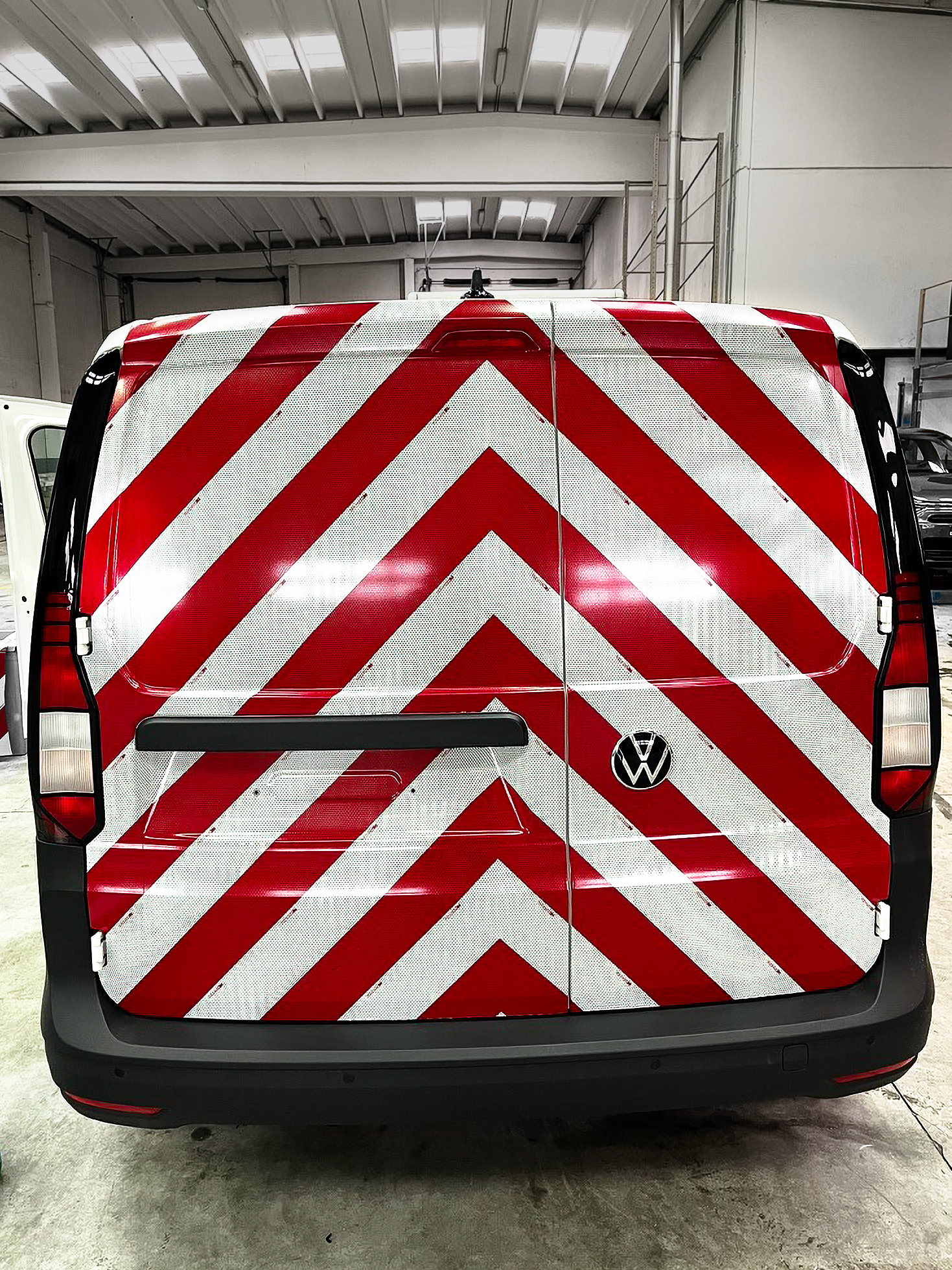 Rood-witte reflecterende 3M-veiligheidsmarkeringen op de achterzijde van een bestelwagen